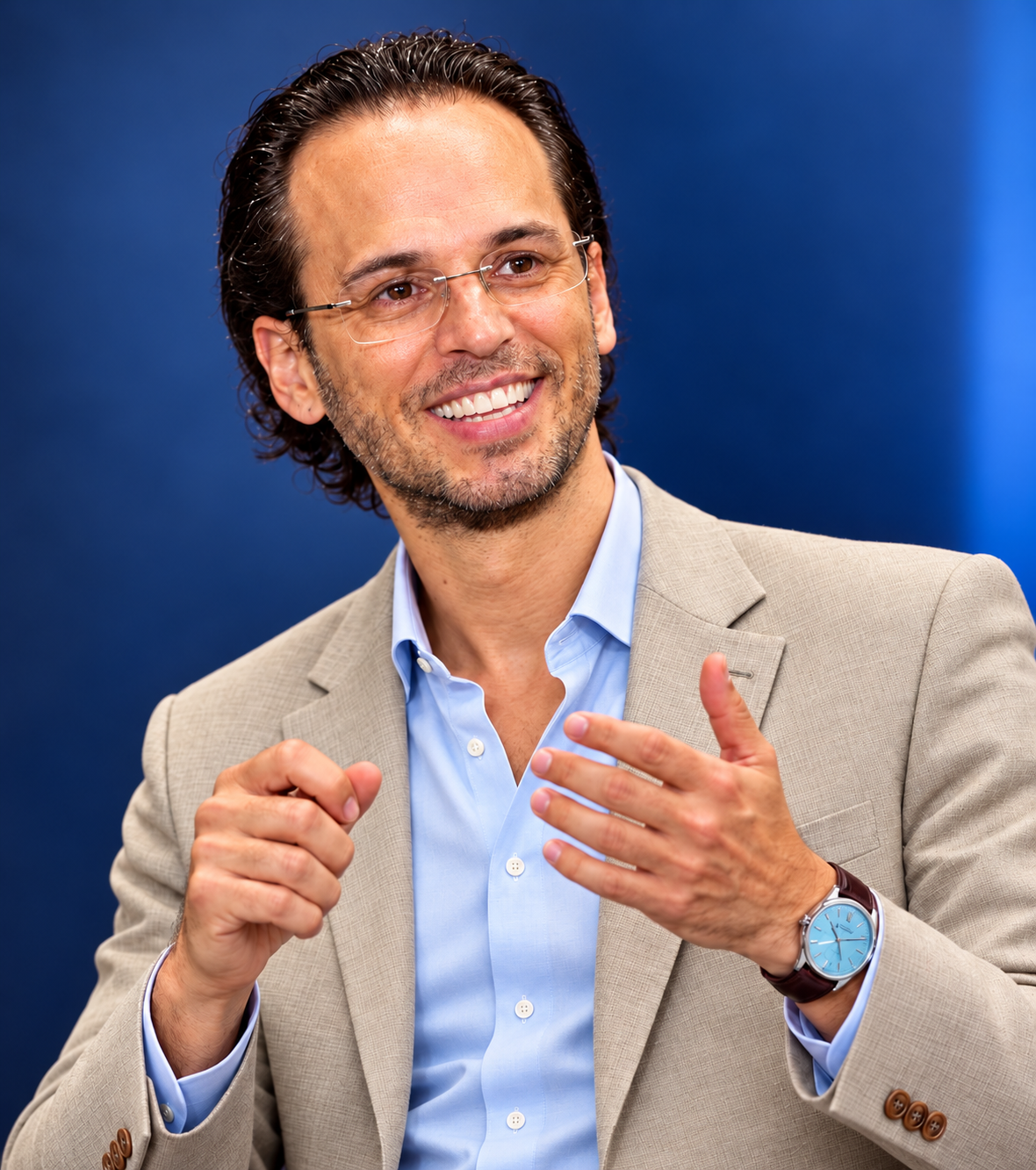 Maicon Savoi sorrindo, de paletó claro, durante uma conversa profissional